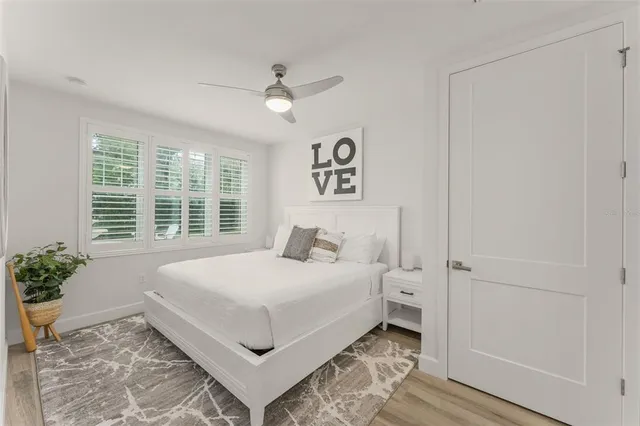 a bedroom with a large bed and a potted plant