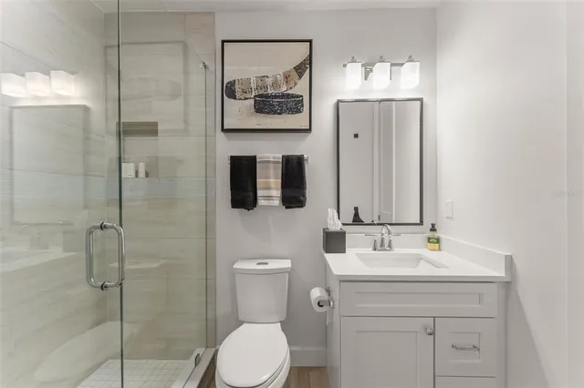 a bathroom with a toilet sink vanity and mirror