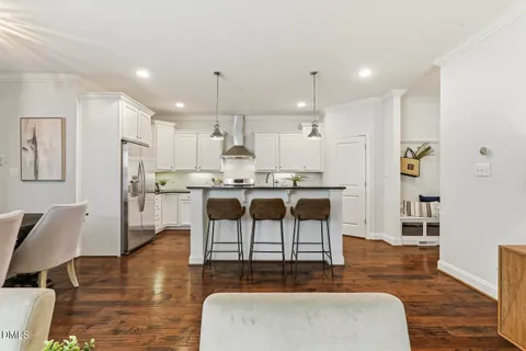 a kitchen with stainless steel appliances granite countertop white cabinets and a stove top oven