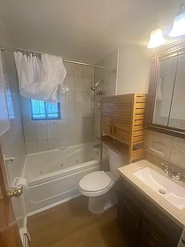 1087 Blake Avenue Brooklyn, NY 11208 - Photo 14 of 16 Full bathroom featuring vanity, wood finished floors, toilet, and washtub / shower combination