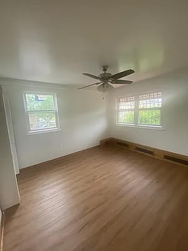 1087 Blake Avenue Brooklyn, NY 11208 - Photo 3 of 16 Spare room featuring a ceiling fan and wood finished floors