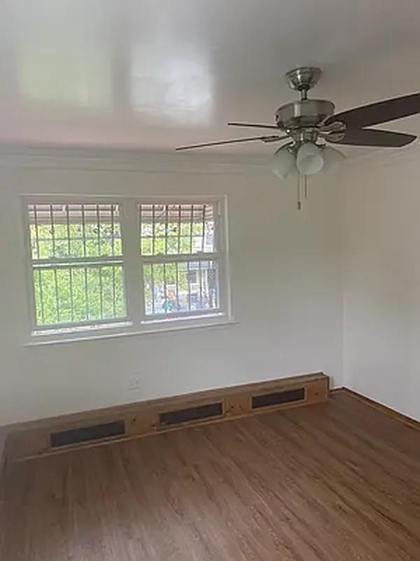 1087 Blake Avenue Brooklyn, NY 11208 - Photo 6 of 16 Unfurnished room with ceiling fan, visible vents, and wood finished floors