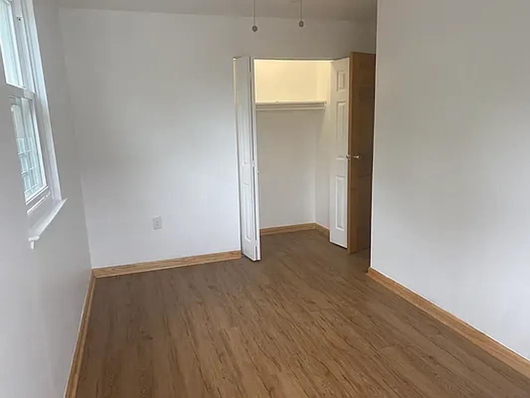 1087 Blake Avenue Brooklyn, NY 11208 - Photo 9 of 16 Unfurnished bedroom with a closet, baseboards, and wood finished floors