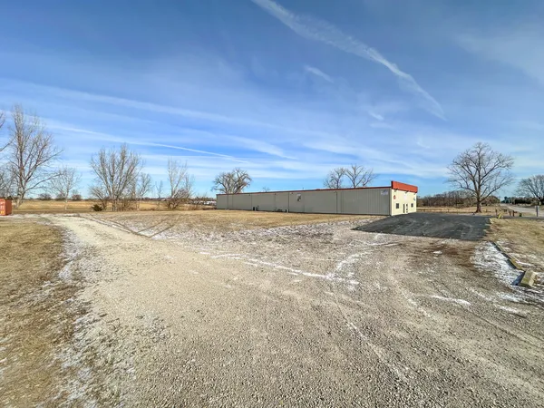 a view of a dry yard with wooden fence