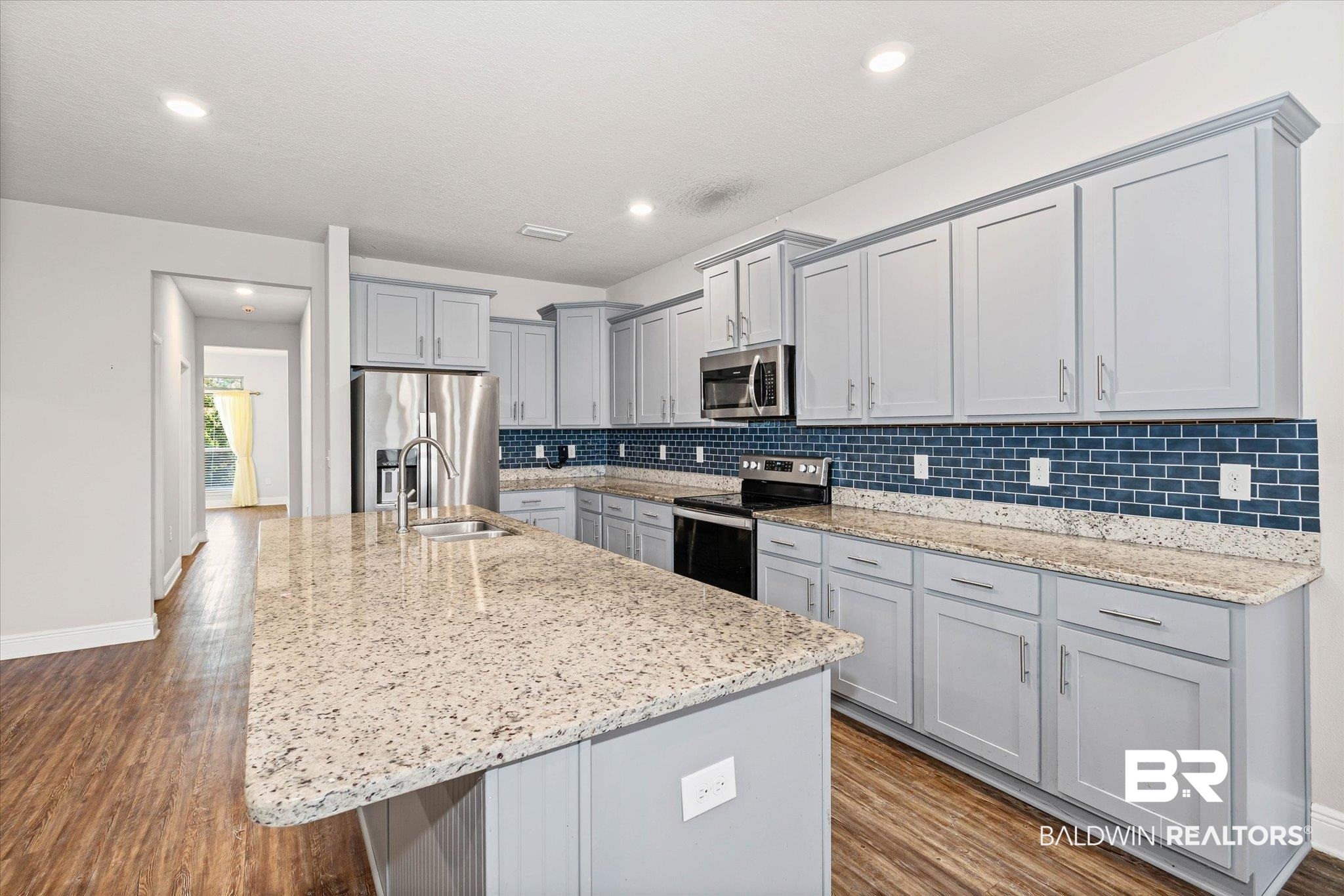 10207 Dunleith Loop Daphne, AL 36526 - Photo 5 of 23 Kitchen featuring gray cabinetry, stainless steel appliances, light stone countertops, dark wood finished floors, and recessed lighting