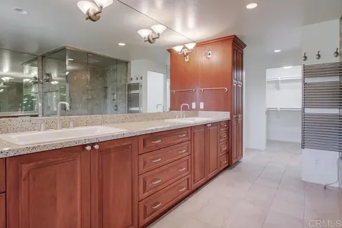 a bathroom with a sink a toilet a mirror and shower