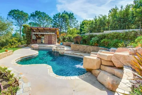a view of a house with swimming pool and sitting area