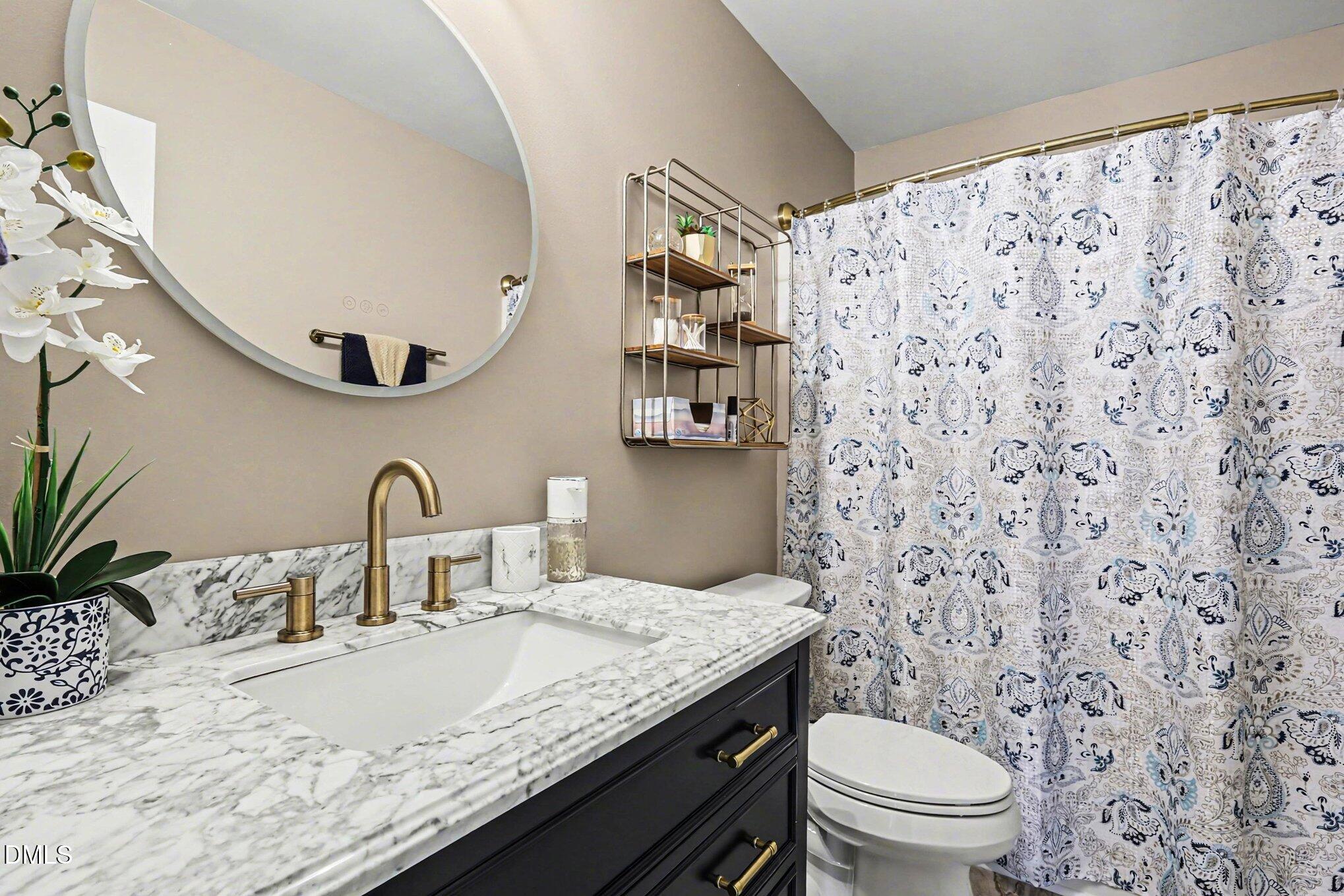 313 Blaze Ridge Drive Smithfield, NC 27577 - Photo 13 of 30 a bathroom with a granite countertop sink mirror vanity and toilet