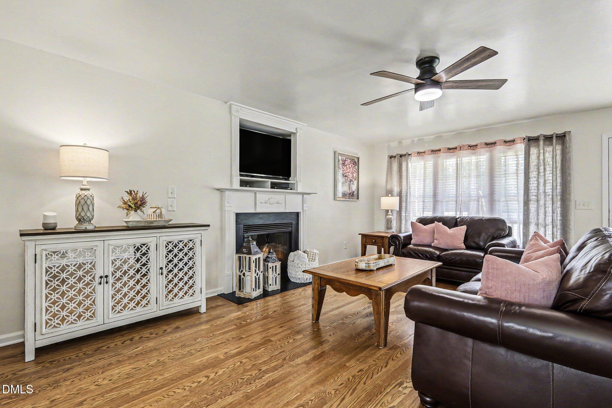 313 Blaze Ridge Drive Smithfield, NC 27577 - Photo 3 of 30 a living room with furniture a fireplace and a flat screen tv