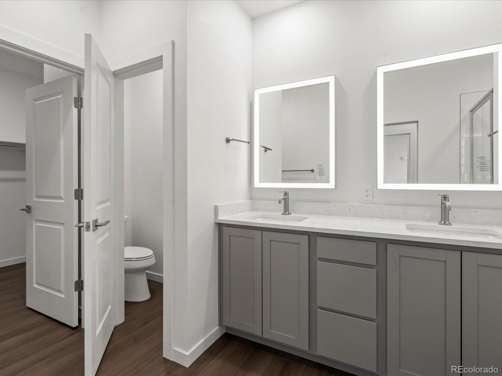 6153 North Ceylon Street, Unit 304 Denver, CO 80249 - Photo 10 of 14 a bathroom with a double vanity sink and mirror