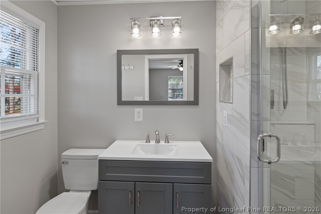 400 Hallmark Road Fayetteville, NC 28303 - Photo 24 of 37 a bathroom with a toilet a sink and mirror