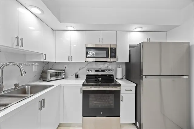 a kitchen with a refrigerator stove and sink