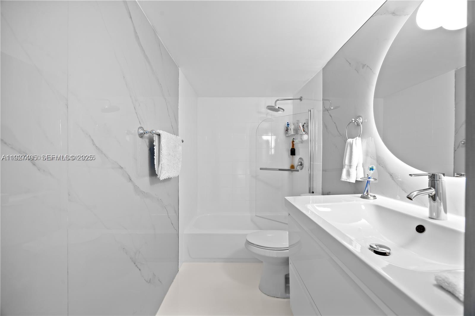 8810 Southwest 132nd Place, Unit 101DN Miami, FL 33186 - Photo 5 of 6 a bathroom with a sink mirror toilet and shower