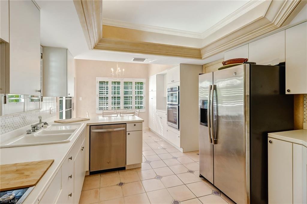 74 Seagate Drive, Unit 4 Naples, FL 34103 - Photo 13 of 35 a kitchen with a refrigerator sink and cabinets