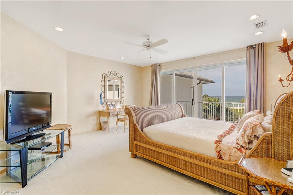 74 Seagate Drive, Unit 4 Naples, FL 34103 - Photo 17 of 35 a bedroom with a bed and glass windows