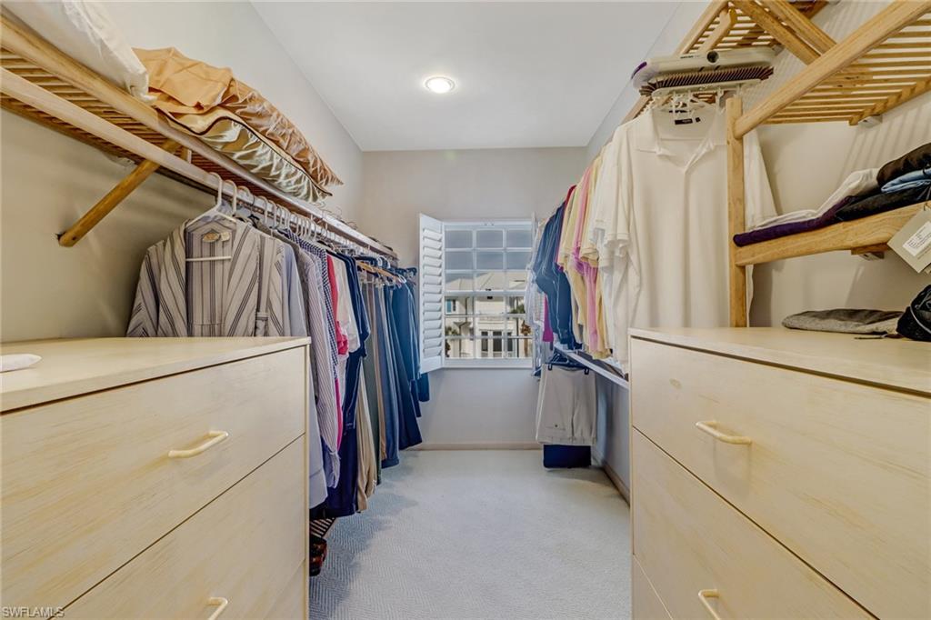 74 Seagate Drive, Unit 4 Naples, FL 34103 - Photo 18 of 35 a view of walk in closet with clothes and shoes