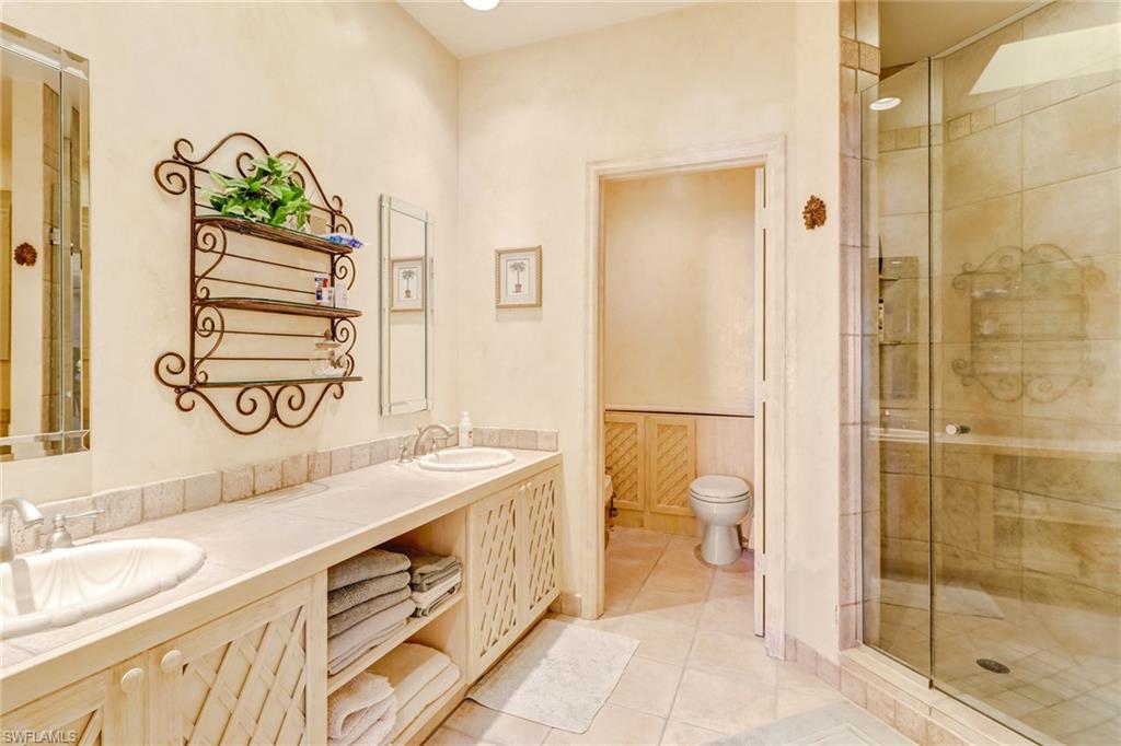 74 Seagate Drive, Unit 4 Naples, FL 34103 - Photo 19 of 35 a spacious bathroom with a granite countertop sink a toilet and shower