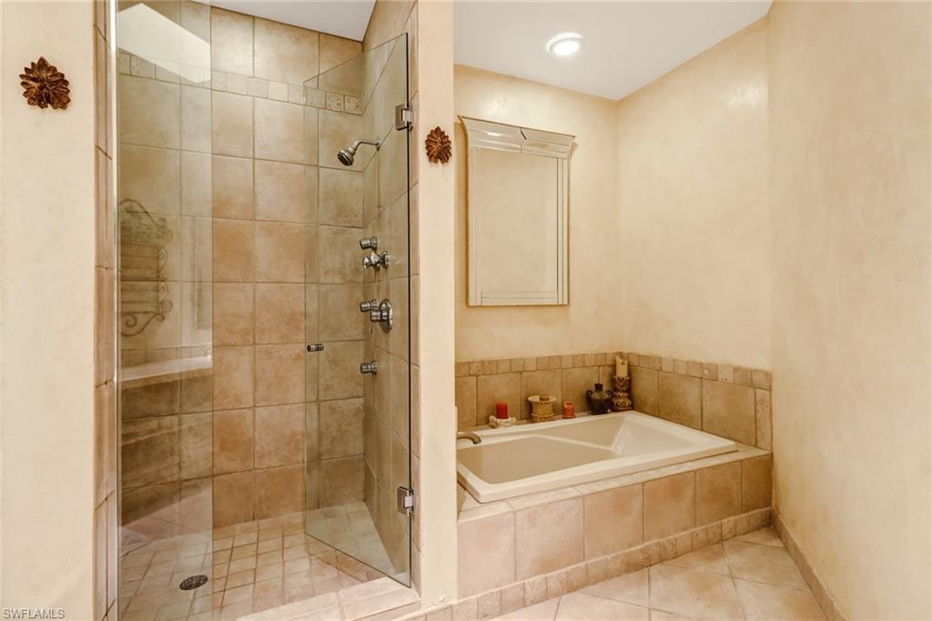74 Seagate Drive, Unit 4 Naples, FL 34103 - Photo 20 of 35 a bathroom with a bathtub and shower