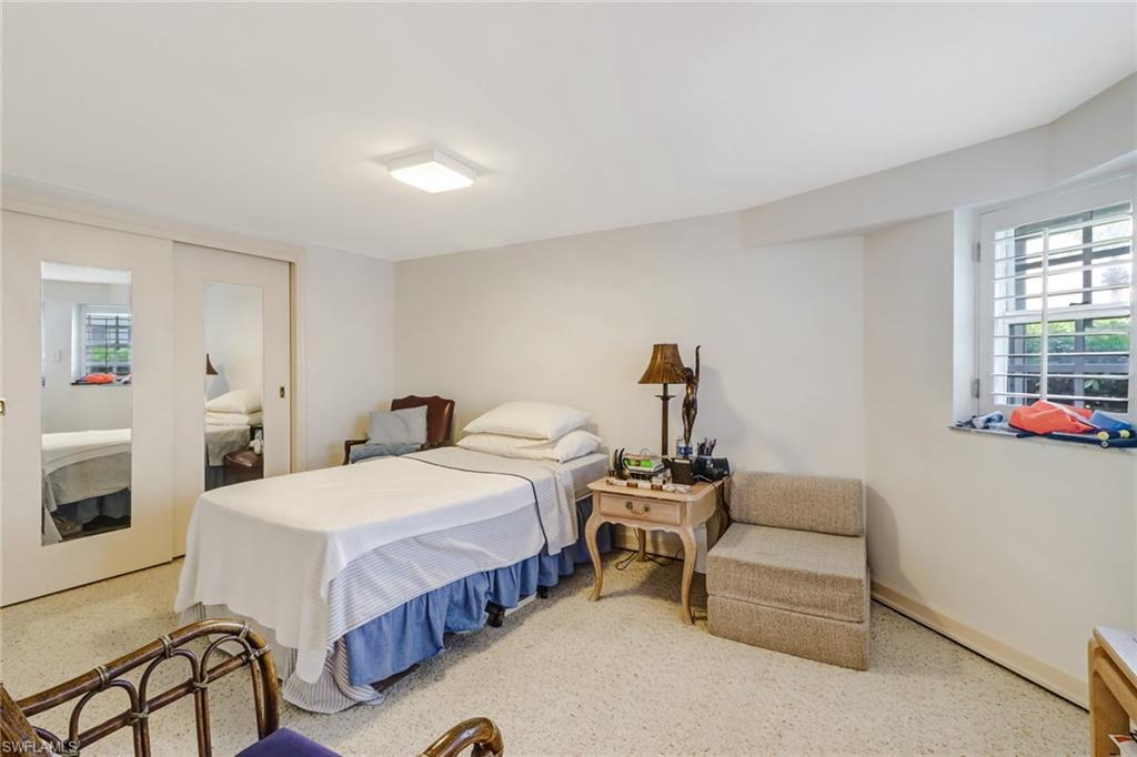 74 Seagate Drive, Unit 4 Naples, FL 34103 - Photo 25 of 35 a bedroom with a bed and a couch