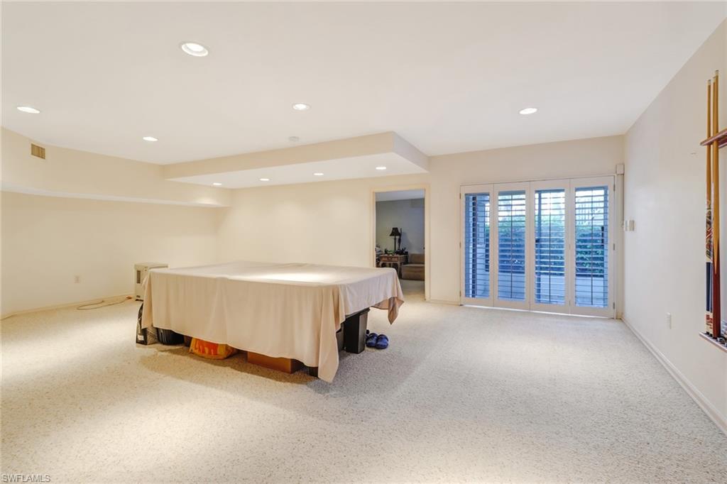 74 Seagate Drive, Unit 4 Naples, FL 34103 - Photo 26 of 35 a spacious bedroom with a bed and a large window