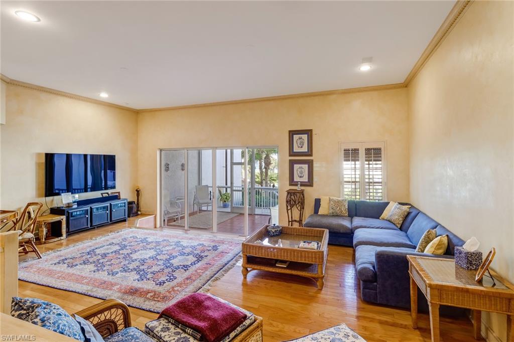 74 Seagate Drive, Unit 4 Naples, FL 34103 - Photo 10 of 35 a living room with furniture a rug and a flat screen tv