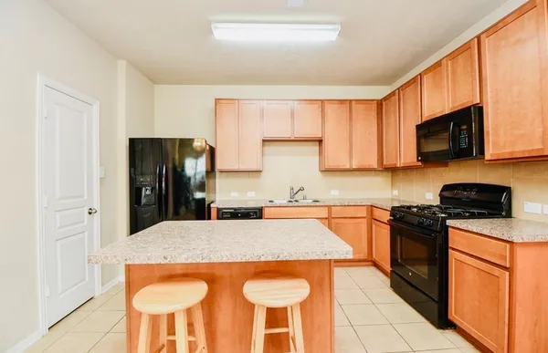 a kitchen with stainless steel appliances granite countertop a refrigerator stove microwave and sink