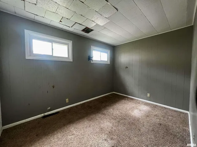 an empty room with windows and closet