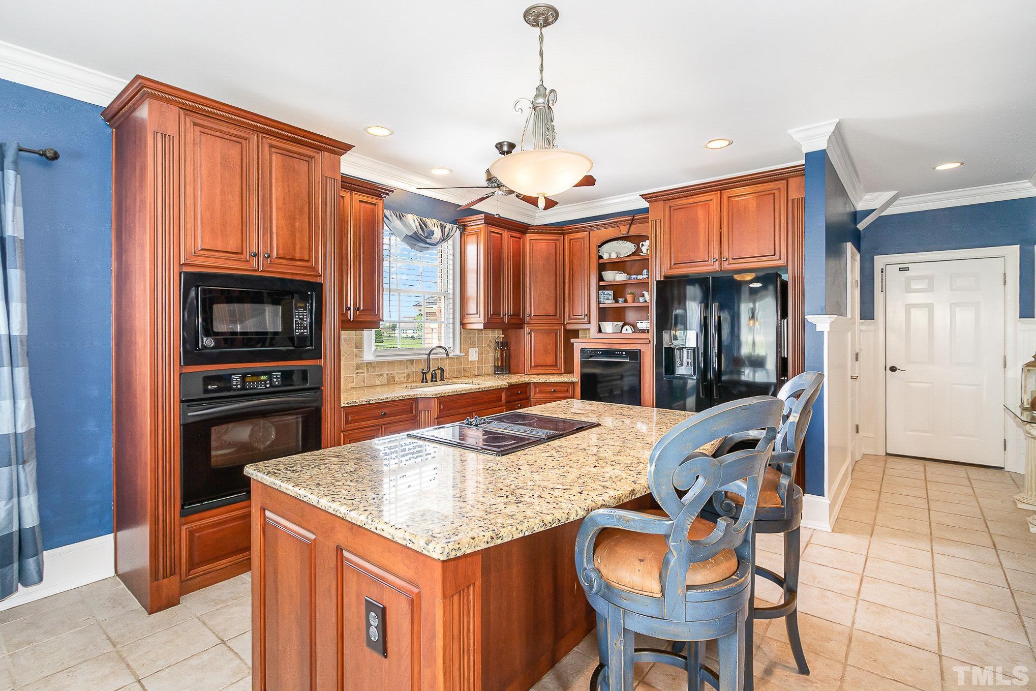 3733 Johnson Pond Road Raleigh, NC 27603 - Photo 14 of 41 a kitchen with granite countertop a table chairs stainless steel appliances and cabinets