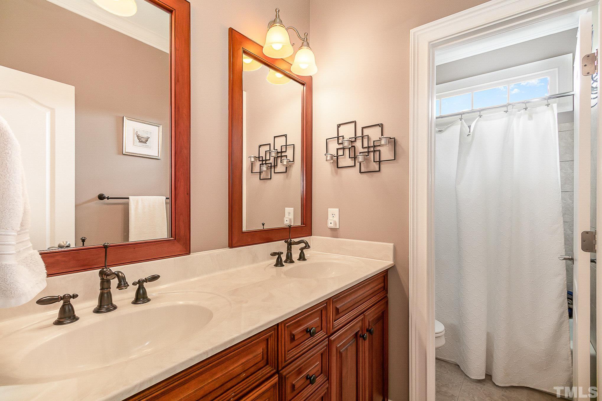 3733 Johnson Pond Road Raleigh, NC 27603 - Photo 24 of 41 a bathroom with a double vanity sink and a mirror
