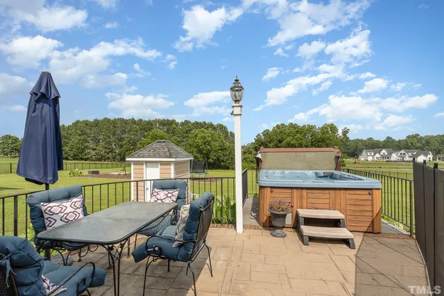 a roof deck with table and chairs and potted plants
