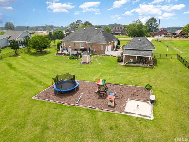 an aerial view of a house with garden space and swimming pool