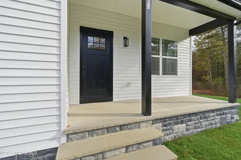 a kitchen with kitchen island a sink a stove a refrigerator and white cabinets