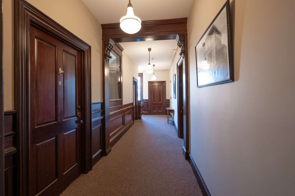 191 Main Street, Unit 3 Gloucester, MA 01930 - Photo 19 of 20 a view of a hallway with wooden floor and staircase