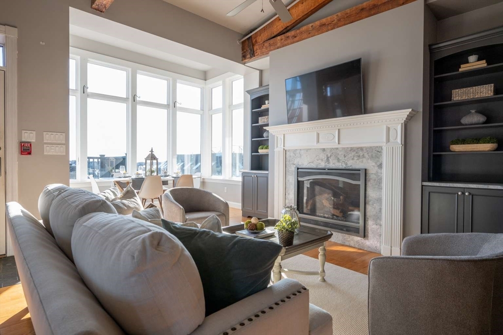 191 Main Street, Unit 3 Gloucester, MA 01930 - Photo 6 of 20 a living room with furniture a fireplace and a flat screen tv