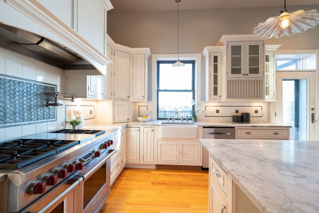 191 Main Street, Unit 3 Gloucester, MA 01930 - Photo 9 of 20 a large kitchen with stainless steel appliances granite countertop a stove and a sink