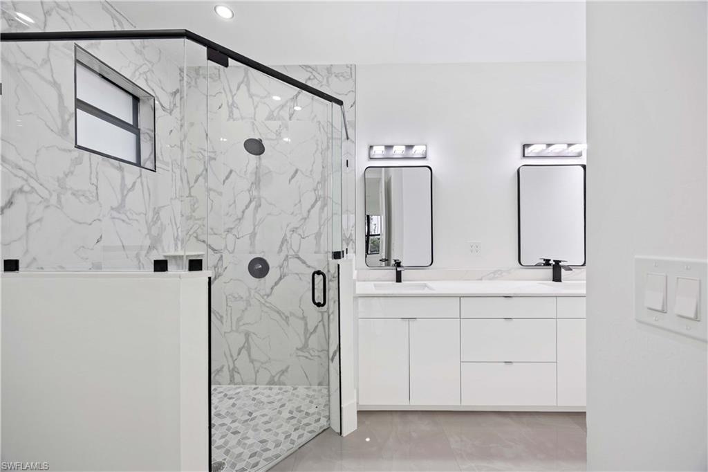 3908 Sunset Road Lehigh Acres, FL 33971 - Photo 18 of 30 a bathroom with a double vanity sink mirror and shower