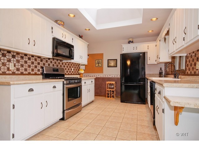 20112 West Manhattan Road Elwood, IL 60421 - Photo 3 of 15 a kitchen with stainless steel appliances kitchen island granite countertop a stove a sink and a microwave