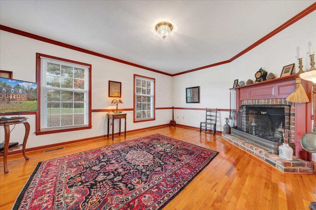 204 Raintree Lane Boones Mill, VA 24065 - Photo 5 of 58 a living room with a rug floor to ceiling window and a fireplace