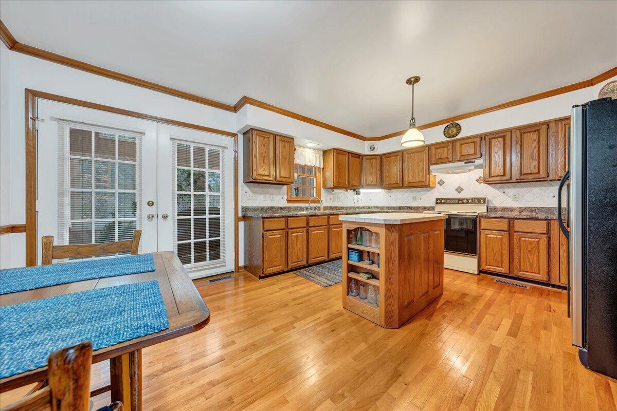 204 Raintree Lane Boones Mill, VA 24065 - Photo 8 of 58 a kitchen with stainless steel appliances granite countertop a stove top oven a sink dishwasher a dining table and chairs with wooden floor