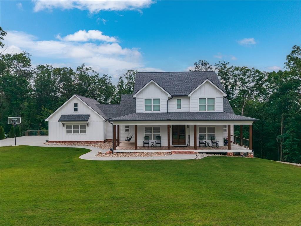 2250 Sperin Road Ball Ground, GA 30107 - Photo 1 of 56 a front view of a house with a yard table and chairs