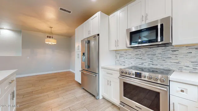a kitchen with granite countertop cabinets stainless steel appliances and wooden floor