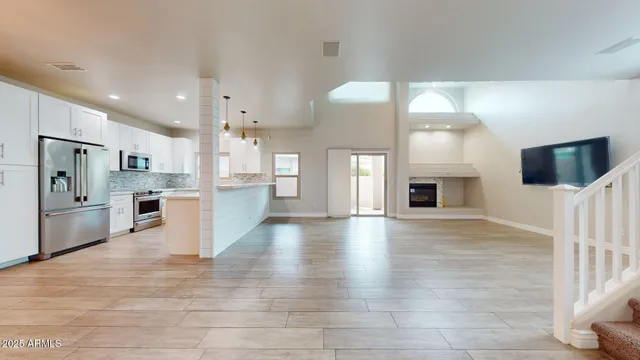 a view of a kitchen with fridge and wooden floor