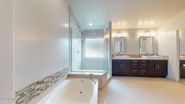 a bathroom with a tub sink vanity and a mirror