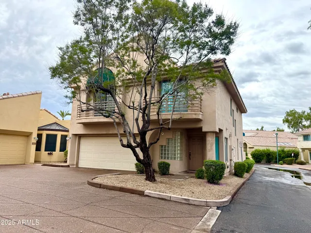 a front view of a house with a tree