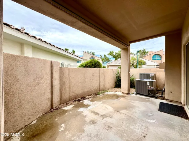 a view of backyard with a large window and wooden fence