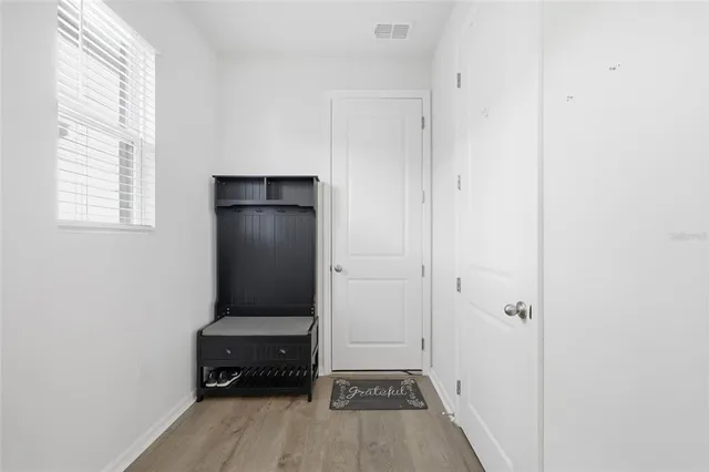 a view of a bedroom with a bed and wooden floor