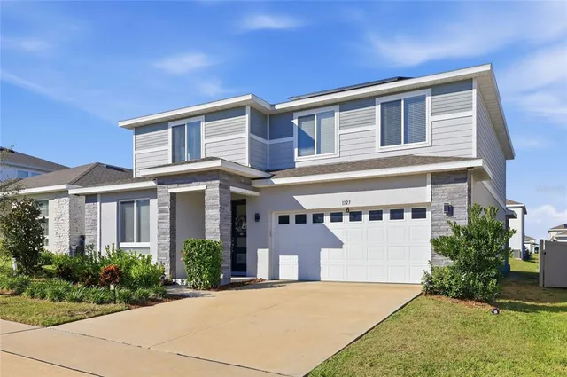 a front view of a building with a garden and plants