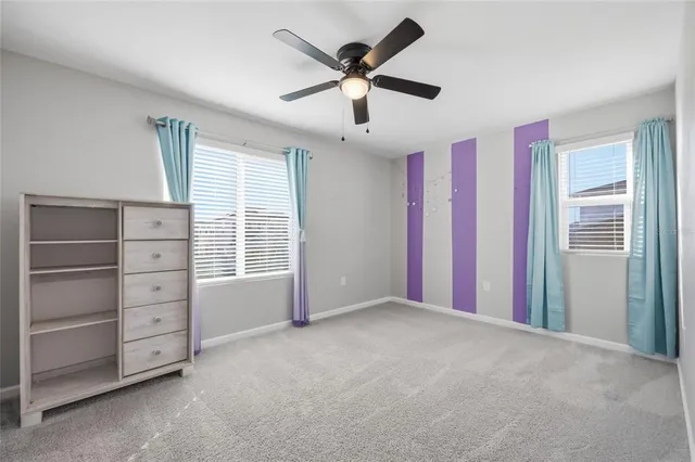 a view of an empty room with a ceiling fan