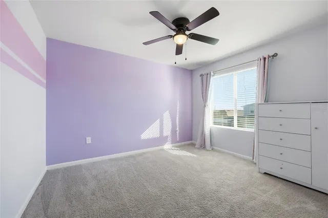 a view of a livingroom with a ceiling fan and window