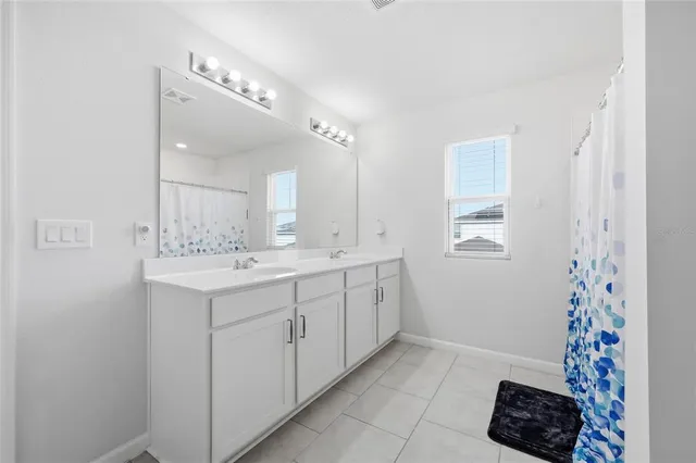 a spacious bathroom with a sink and a mirror